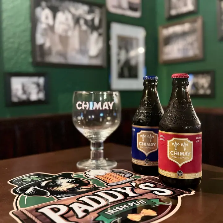 Botellas de Chimay azul y roja con su copa sobre un posavasos de Paddy’s.
