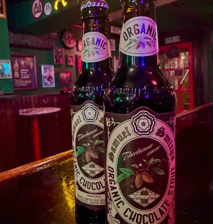 Dos botellas de Samuel Smith Organic Chocolate Stout en la barra.