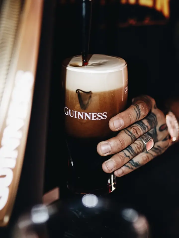 Una Guinness asentándose en la barra, en blanco y negro.