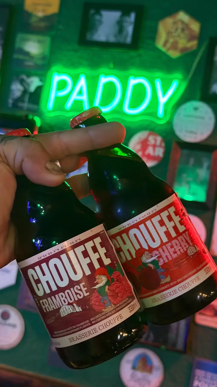 Dos botellas de Chouffe Framboise delante del neón verde PADDY.