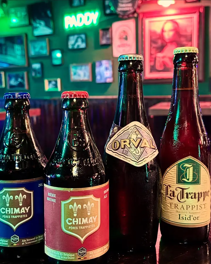 Botellas de cervezas trapenses en fila sobre la barra.